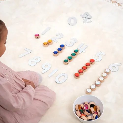 Houten speelgoed én creatief plezier! Met de rijgjuwelen van Tickit leren kinderen kleuren combineren, tellen, patronen maken en rijgen.